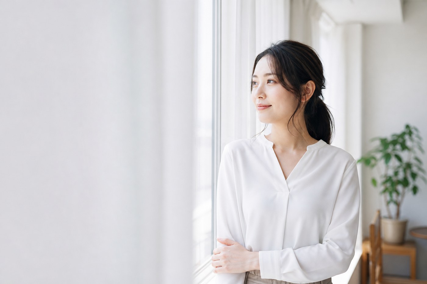 窓辺で微笑む働く女性